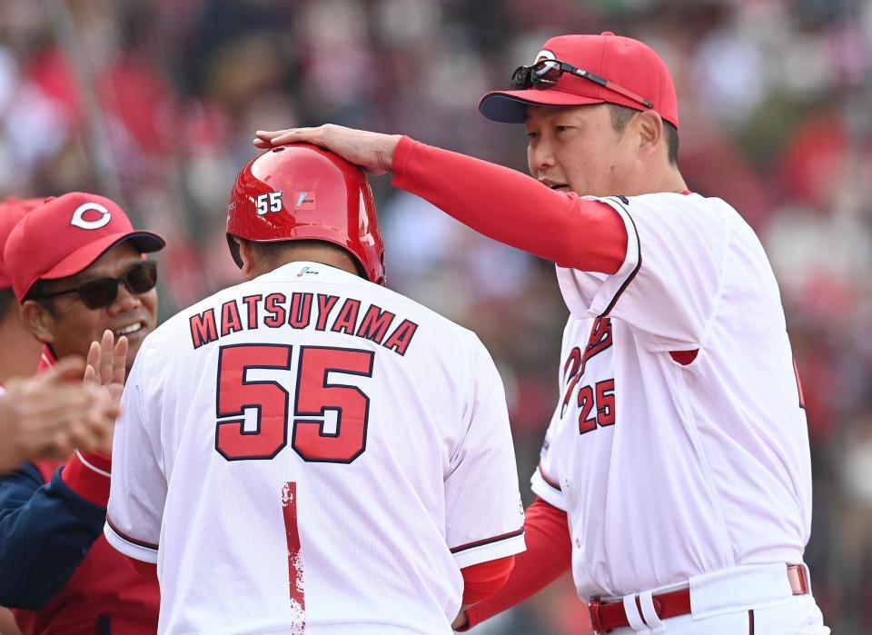 　土壇場で同点打を放った松山のヘルメットをたたいて祝福する新井監督（撮影・田中太一）