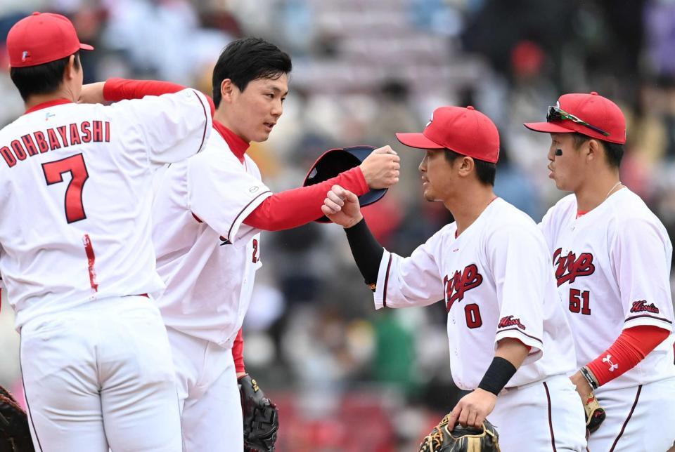 　９回、三者連続三振で締めた栗林はナインとタッチを交わす