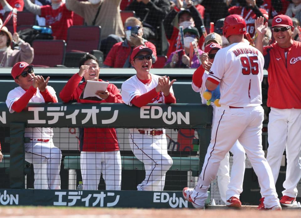 　４回、右越えソロを放ったデビッドソン（右）を「ゴマすり」ポーズで迎える新井監督（中央）ら