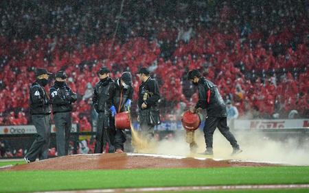 　７回、ぬかるんだマウンドに砂を入れるスタッフ（撮影・田中太一）