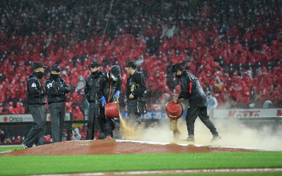 　７回、ぬかるんだマウンドに砂を入れるスタッフ（撮影・田中太一）