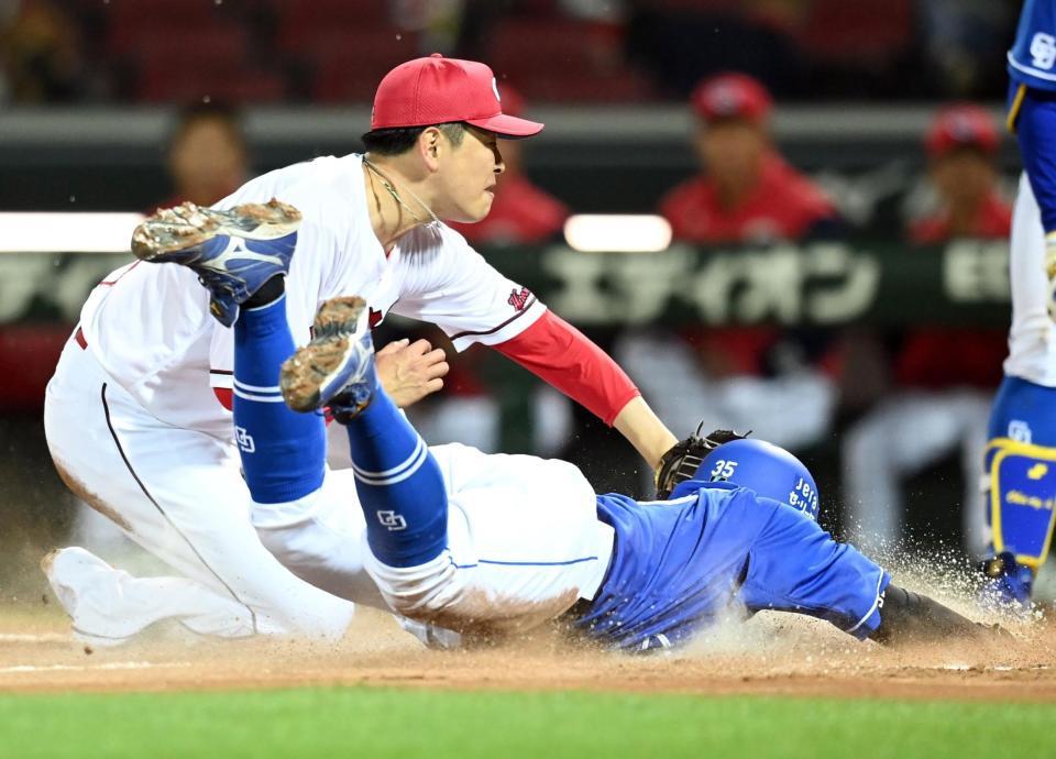 　４回、捕逸で大瀬良がベースカバーに入るも、木下が生還、勝ち越しを許す（撮影・田中太一）