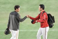 　試合前、村田コーチ（左）とグータッチする栗林（撮影・伊藤笙子）