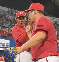 　試合を締めた矢崎（手前）を迎える新井監督（撮影・伊藤笙子）