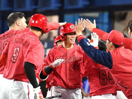 　９回、ナインに迎えられ笑顔の坂倉（中央）