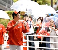 　沿道のファンに手を振って、室内練習場へ移動する新井監督（撮影・田中太一）