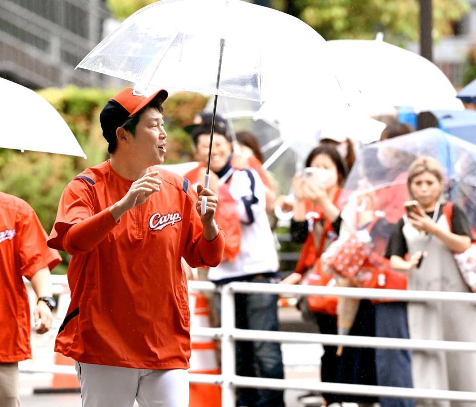 　沿道のファンに手を振って、室内練習場へ移動する新井監督（撮影・田中太一）
