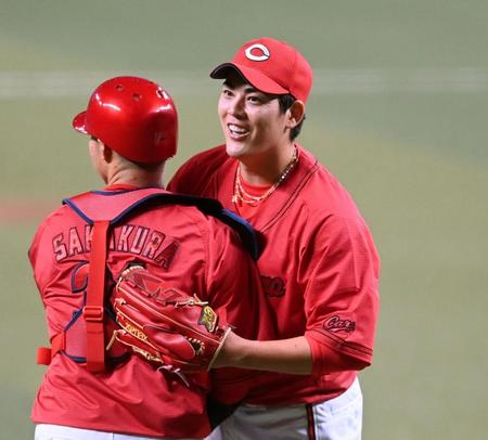 　完封勝利を挙げ、坂倉と喜び合う九里（撮影・田中太一）