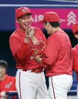 　完封勝利の九里（右）を迎える新井監督