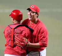 　完封勝利を挙げ、坂倉と喜び合う九里（撮影・田中太一）