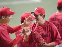 　完封勝利を挙げた九里は新井監督に迎えられ笑顔を見せる（撮影・田中太一）