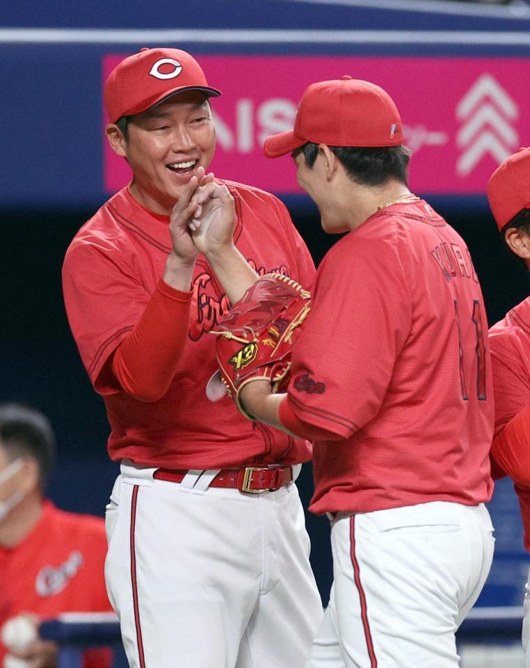 　完封勝利の九里（右）を迎える新井監督