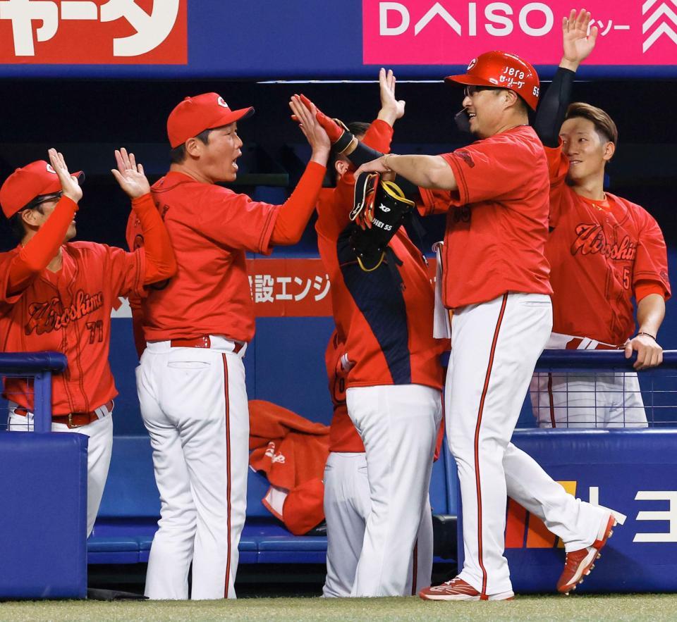 　１１回、代打で決勝となる二塁打を放ち、新井監督（左から２人目）らに迎えられる松山