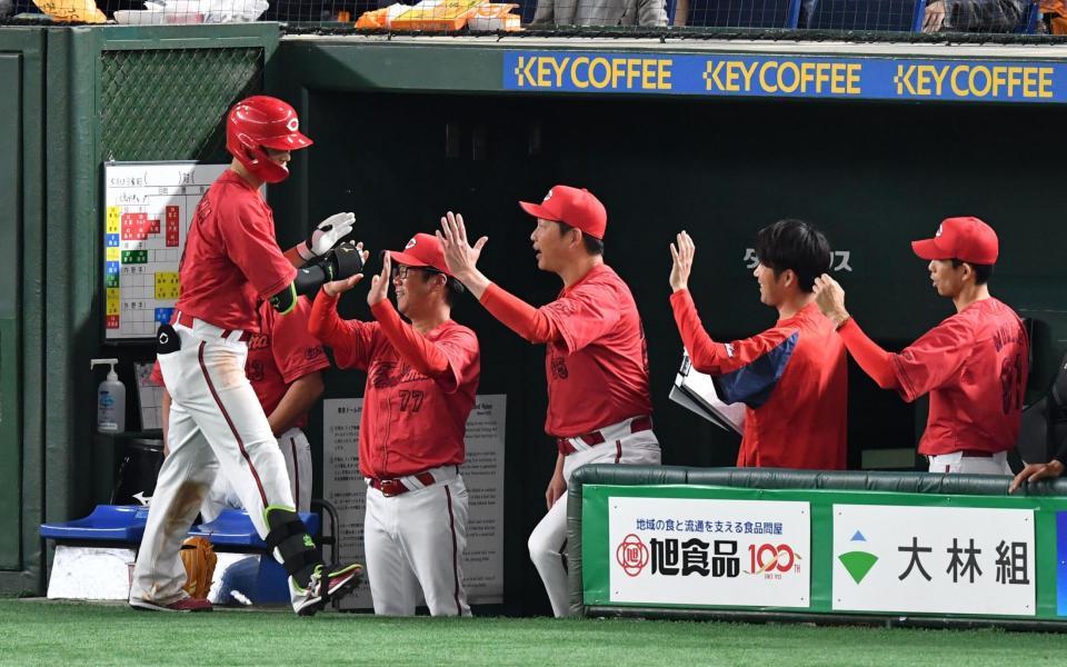 　４回、右越えにソロを放ちベンチ前で新井監督に出迎えられる西川（撮影・佐々木彰尚）