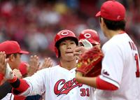 　１回、２ランを放った坂倉は九里とタッチを交わす（撮影・田中太一）