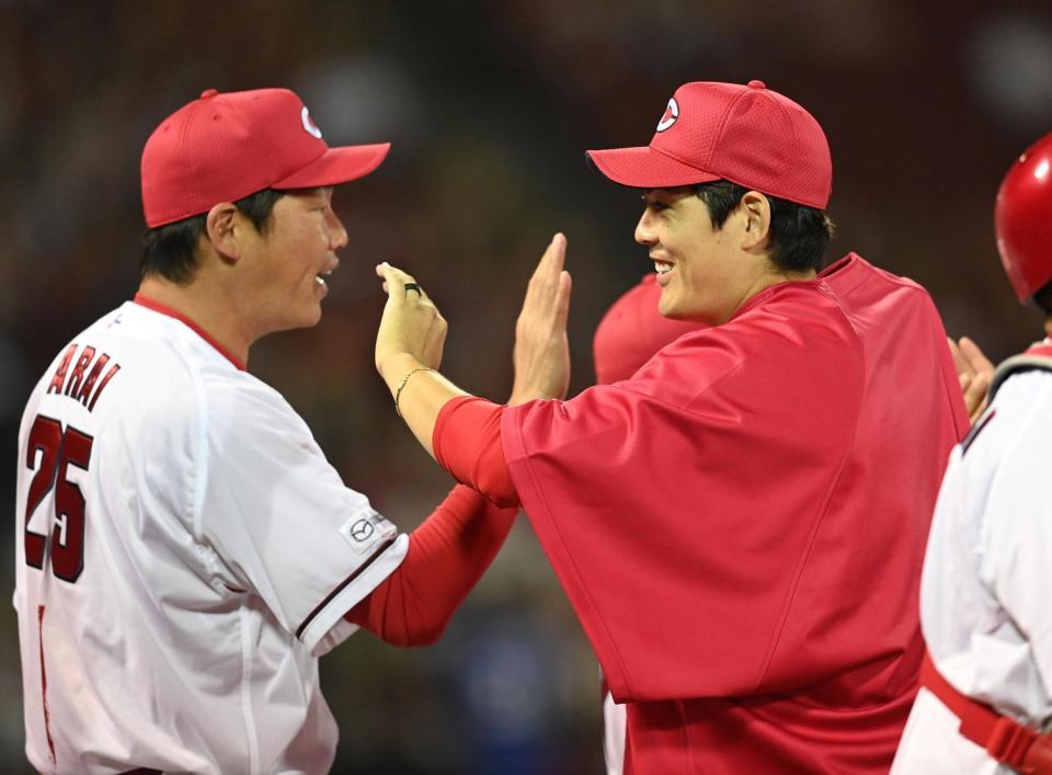 　勝ち星を挙げ、新井監督とタッチを交わす九里（撮影・田中太一）