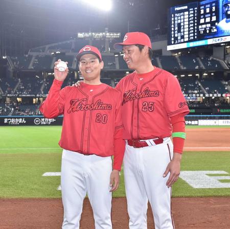 　プロ初勝利を挙げウイニングボールを手に新井監督（右）から祝福される栗林（撮影・中島達哉）