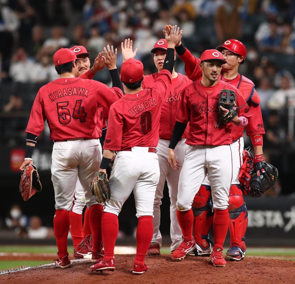 　勝利をあげ、タッチを交わす矢崎（中央奥）ら広島ナイン（撮影・中島達哉）
