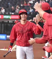 　５回、先制ソロを放ち、ナインに迎えられる坂倉