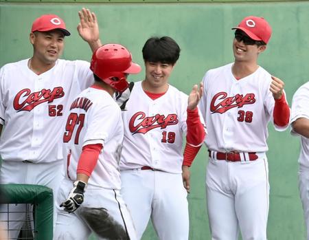 　６回、生還した中村貴を笑顔で迎える野村（中央）＝撮影・田中太一