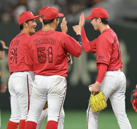 　今季初完封勝利をあげ、小園（中央）らとハイタッチを交わす森下（右）＝撮影・伊藤笙子