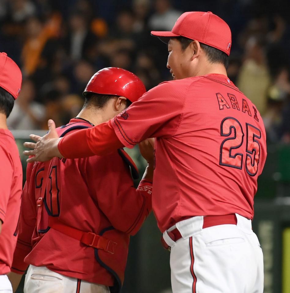 　延長戦を制し、坂倉（左）をねぎらう新井監督（撮影・伊藤笙子）