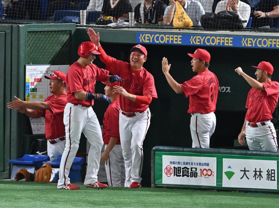 　１１回、坂倉の中前２点打に喜ぶ新井監督（中央）ら広島ベンチ
