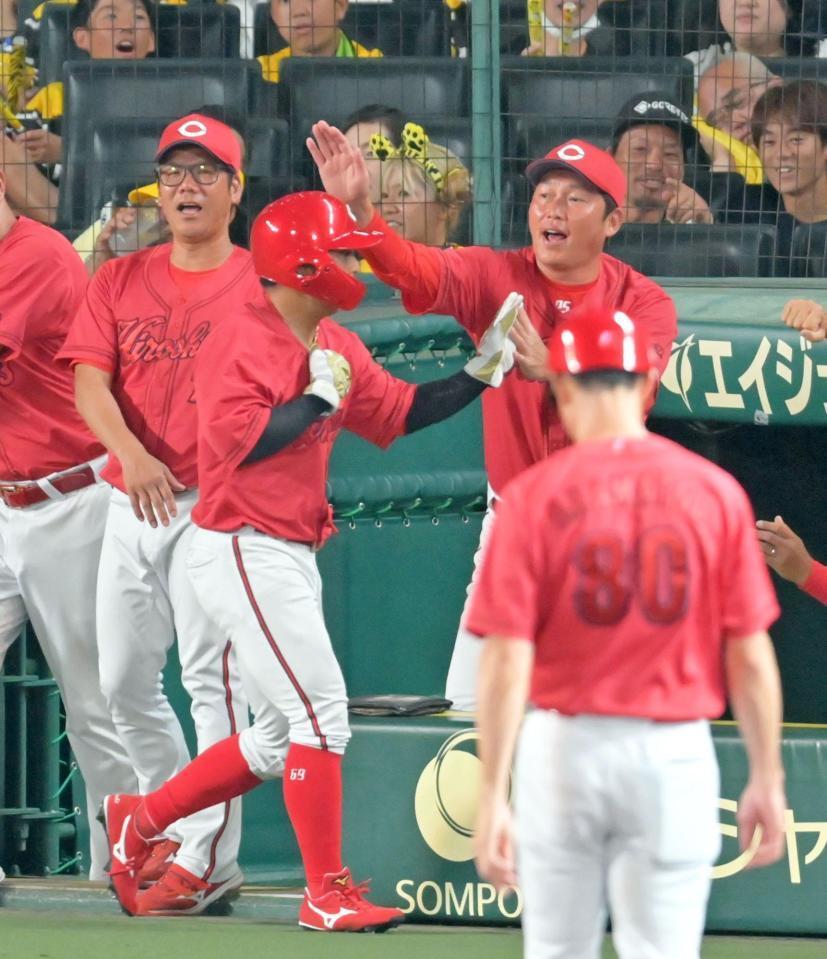 　８回、小園の同点適時二塁打で生還した羽月とタッチを交わす新井監督（２９日）