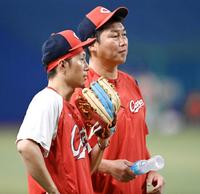 　７月９日、試合前の練習中話をする新井監督と西川