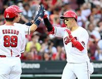 　１回、同点２ランを放ち野村に迎えられる小園（撮影・田中太一）