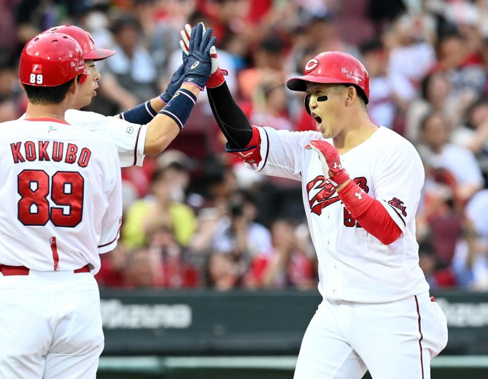 　１回、同点２ランを放ち野村に迎えられる小園（撮影・田中太一）