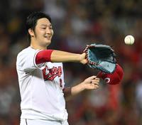 　完封で１０勝目を挙げた床田は堂林からウイニングボールを受け取り笑顔を見せる（撮影・田中太一）