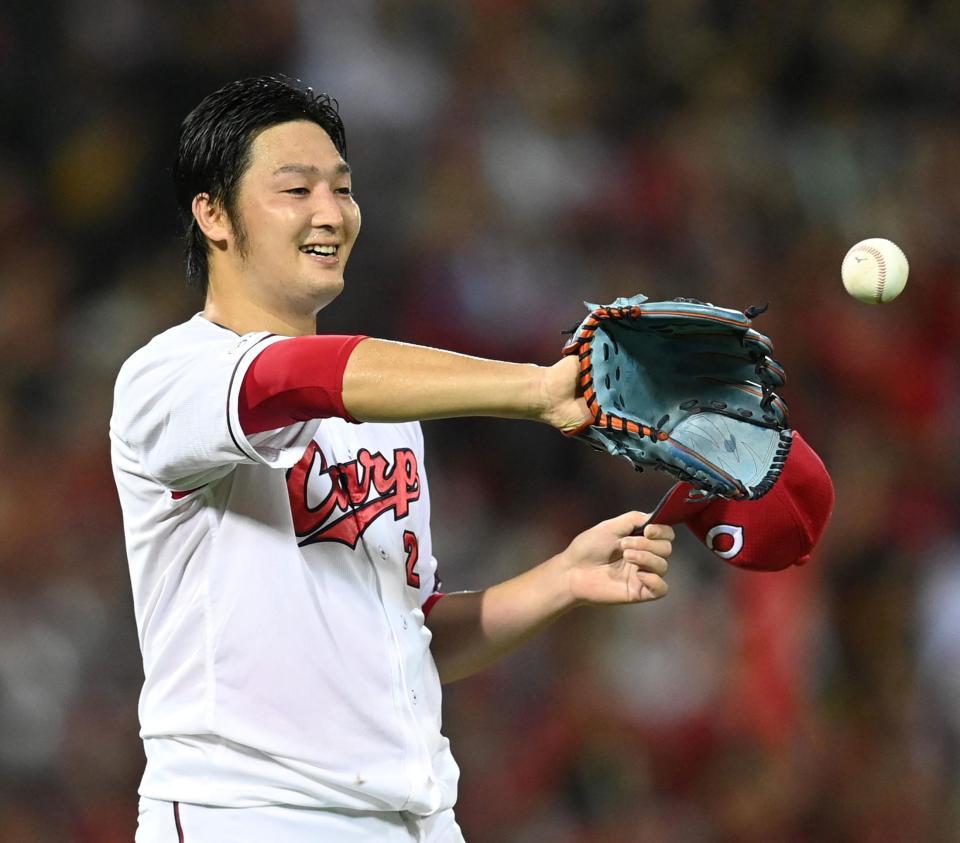 　完封で１０勝目を挙げた床田は堂林からウイニングボールを受け取り笑顔を見せる（撮影・田中太一）