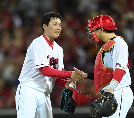 　９回を締めた栗林（左）は会沢からウイニングボールを受け取り握手