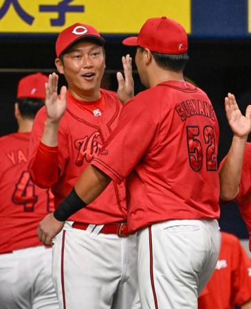 　巨人に勝利し末包（右）とタッチを交わす新井監督