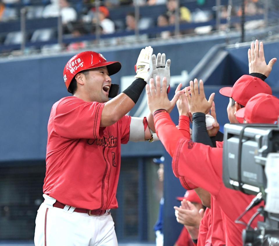 　５回、ソロを放った末包（左）はナインとタッチを交わす（撮影・北村雅宏）