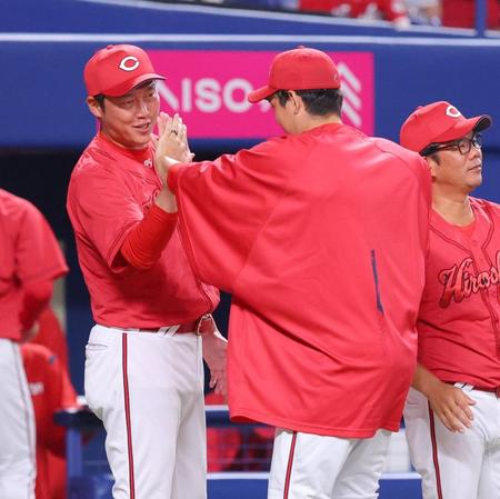 　中日に勝ち、九里（右）とハイタッチを交わす新井監督