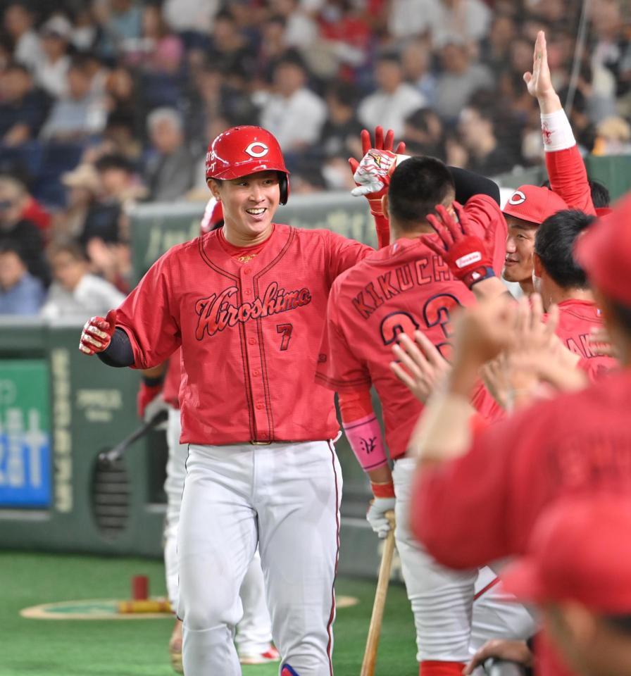 　２回、先制ソロを放ち、笑顔でナインとタッチする堂林（撮影・西岡正）