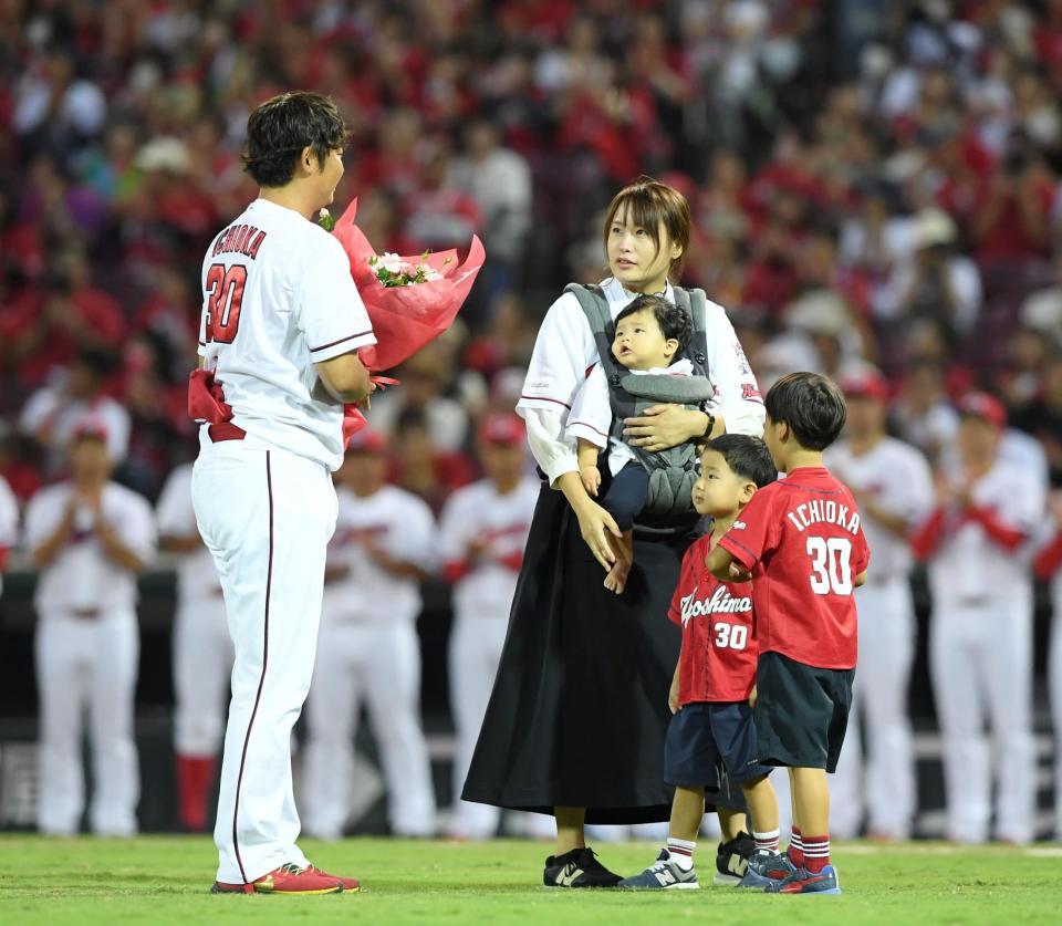 引退する一岡（左）に花束を渡した妻の紀美子さん（撮影・中田匡峻）