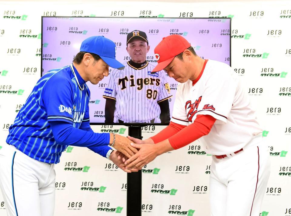 　会見を終え、モニターの岡田監督を挟んで握手をする新井監督と三浦監督（撮影・田中太一）