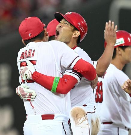 　１１回、サヨナラ打を放った秋山は新井監督と抱き合って歓喜する（撮影・田中太一）