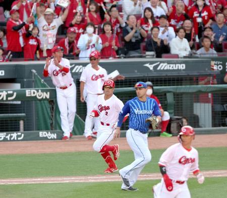 ８回、勝ち越し打を放ち、一塁へ走る代打・田中（２）。後方左は喜ぶ新井監督