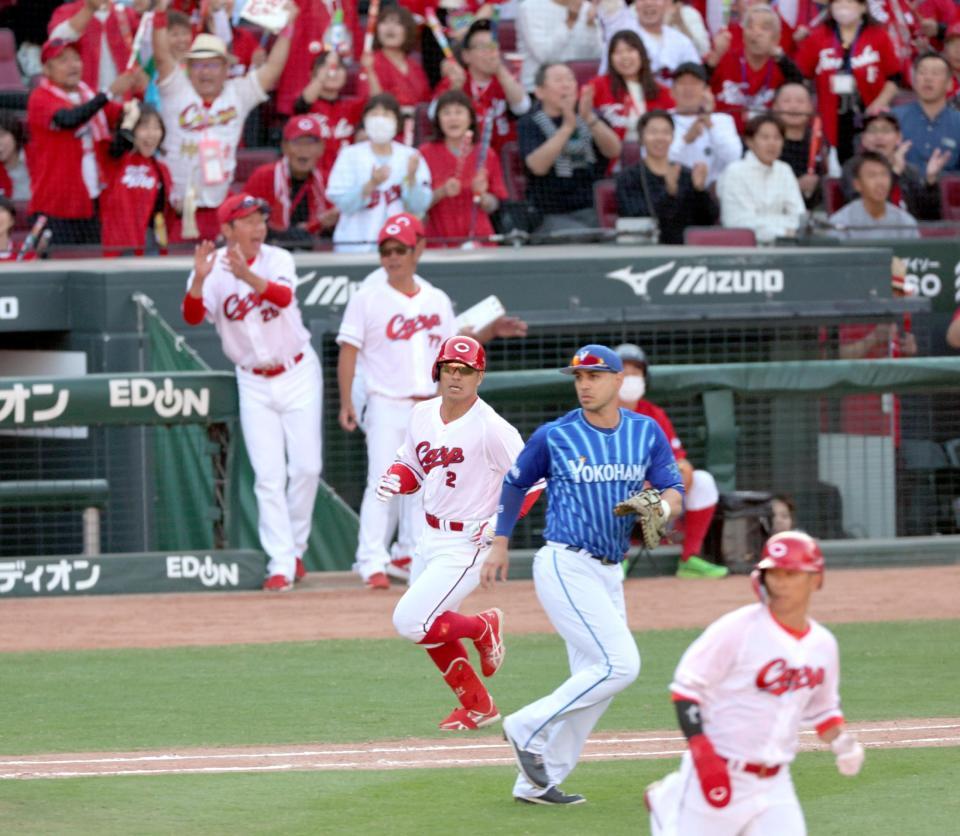 ８回、勝ち越し打を放ち、一塁へ走る代打・田中（２）。後方左は喜ぶ新井監督