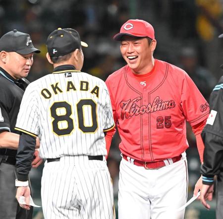 　岡田監督（80）と試合前のメンバー交換を行う新井監督（撮影・高部洋祐）