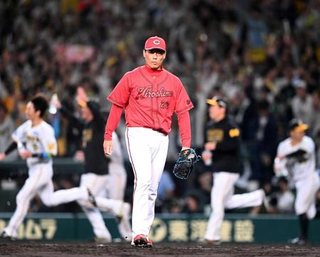 　９回、沸き上がる阪神ナインを背に引き揚げる栗林
