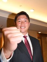 　くじを引く黄金の右手を披露する新井監督（撮影・佐々木彰尚）