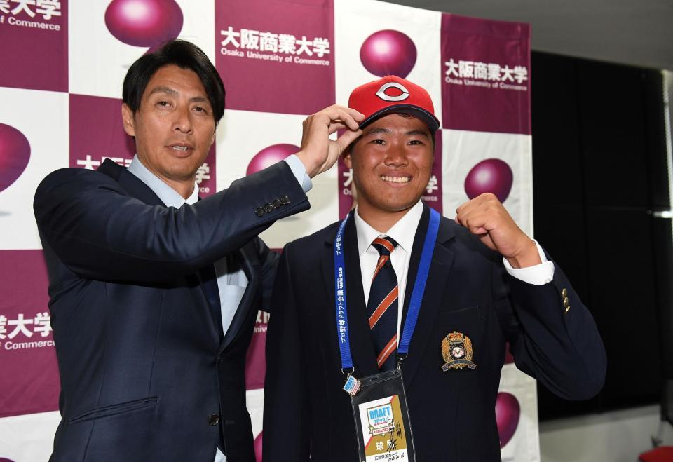 　鞘師スカウト（左）に帽子をかぶらせてもらう高（撮影・北村雅宏）