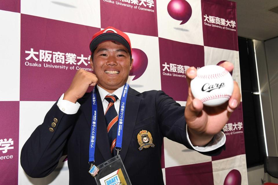 　指名あいさつを終え、笑顔でポーズを決めるドラフト２位指名の大商大・高（撮影・北村雅宏）