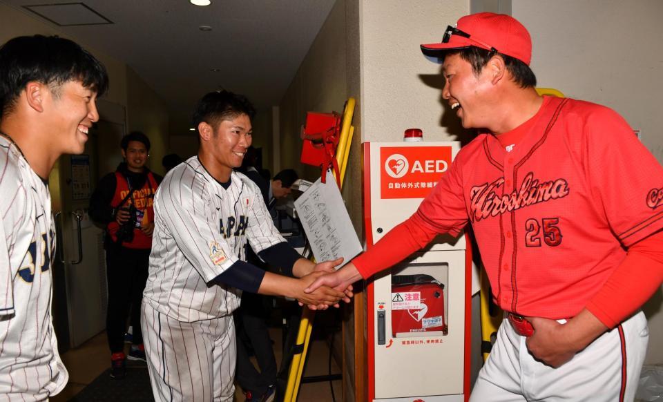 　試合後、新井監督（右）と握手を交わす坂倉と小園（左端）＝撮影・中田匡峻