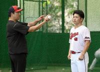 　投球後、黒田博樹球団アドバイザーから指導を受ける広島・河野佳＝日南